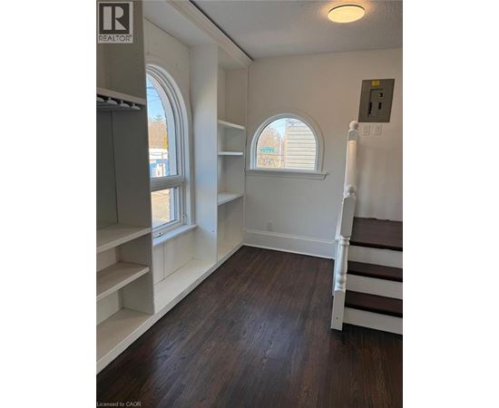 A kitchen with a staircase and a refrigerator.