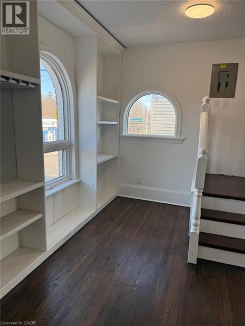 A kitchen with a staircase and a refrigerator.
