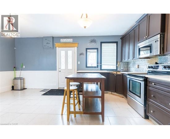 A kitchen with a table and chairs in front of a window.