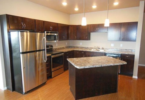 a kitchen with a stainless steel refrigerator