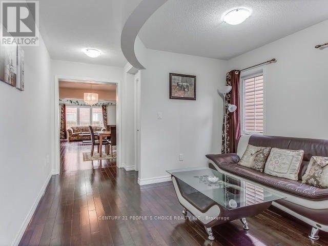 A living room with a couch, coffee table, and a painting on the wall.