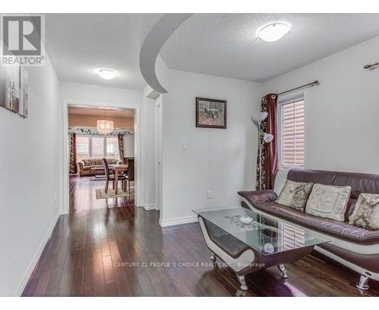 A living room with a couch, coffee table, and a painting on the wall.