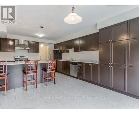 A kitchen with brown cabinets and a white ceiling.