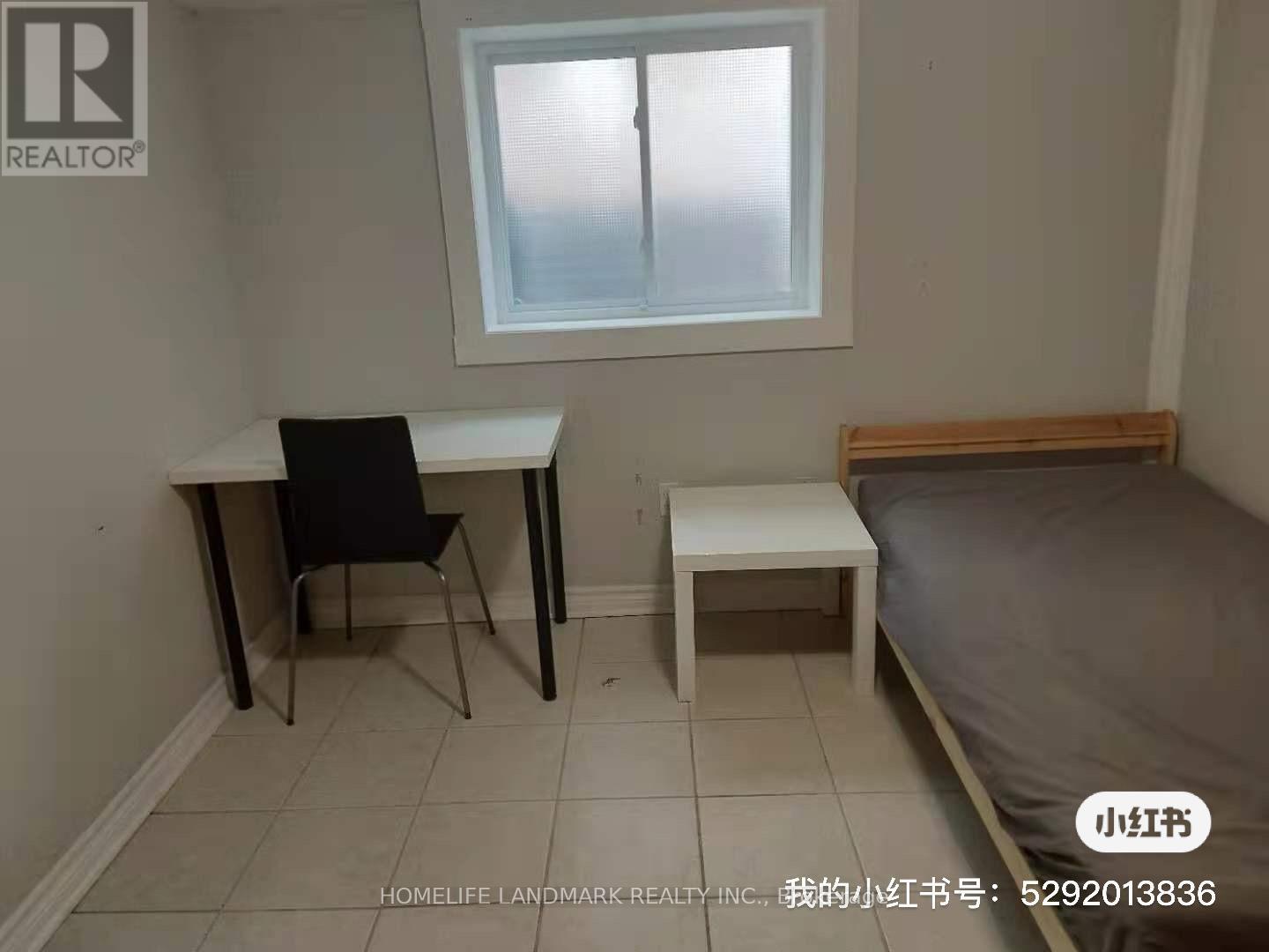 A small bedroom with a bed, desk, and chair.