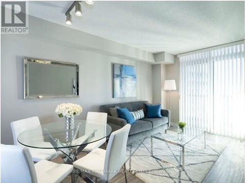 A modern living room with a glass table and white chairs.