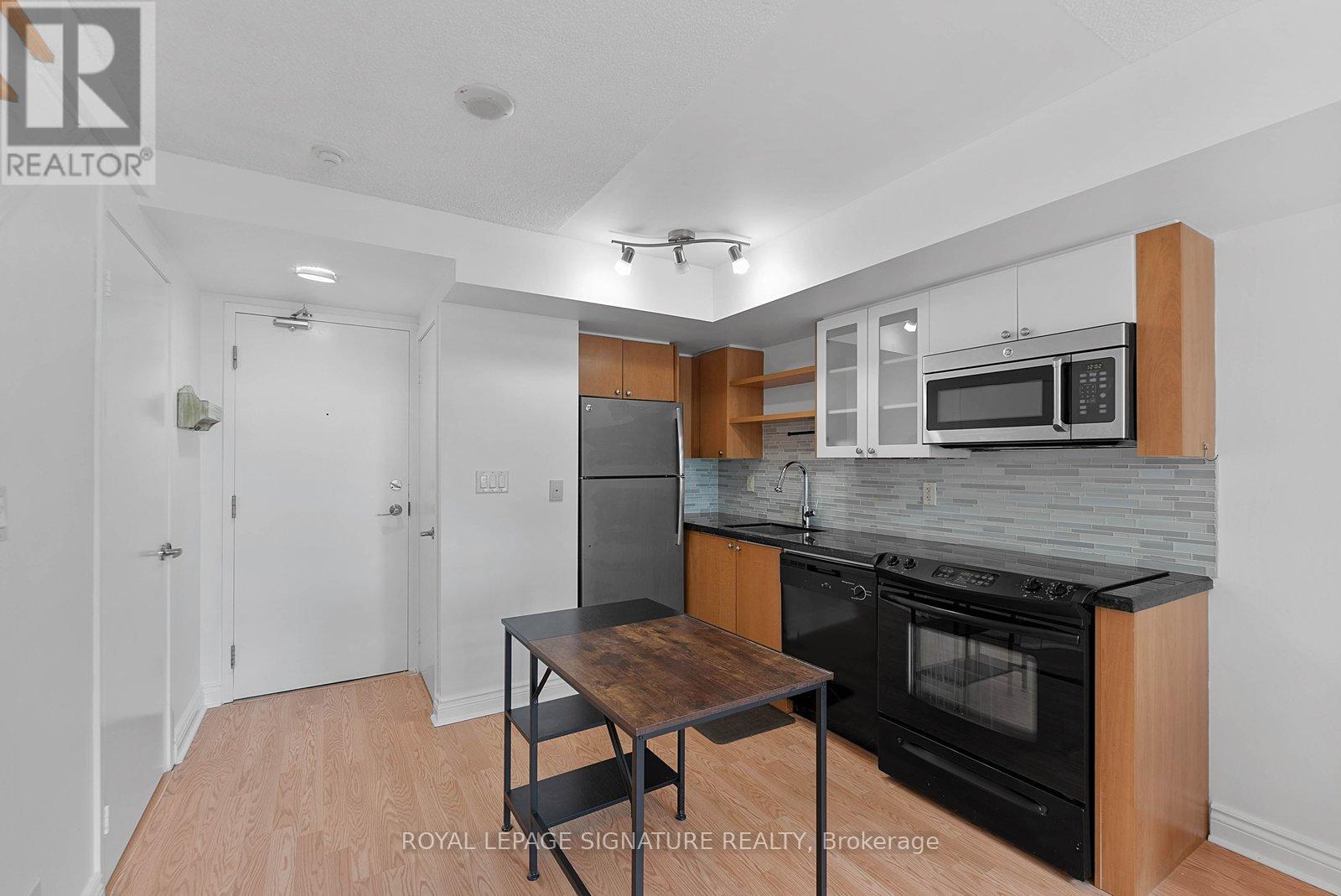 A kitchen with a table and a microwave oven.