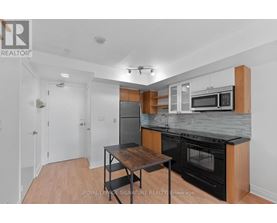 A kitchen with a table and a microwave oven.