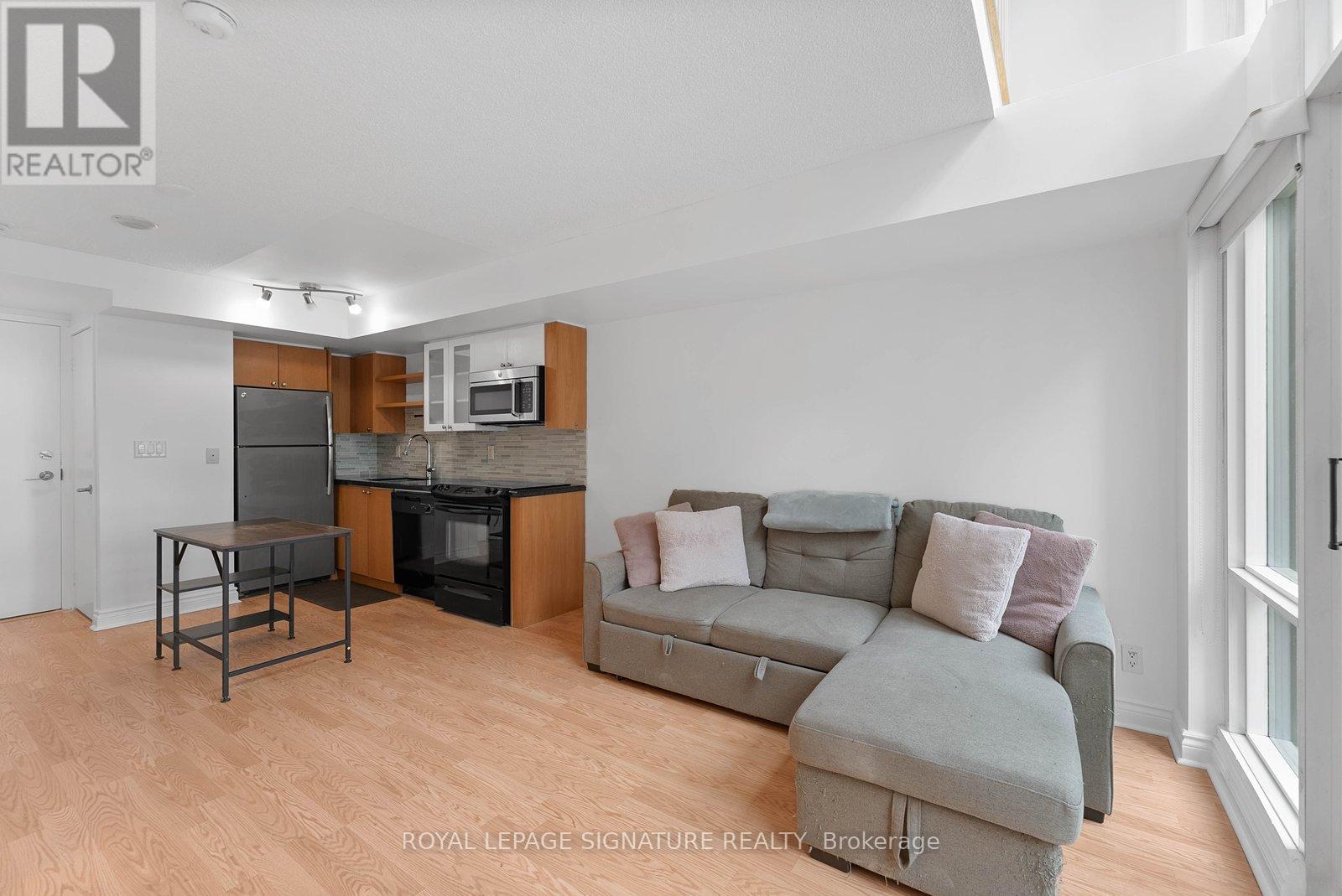 A living room with a grey couch and a black table.
