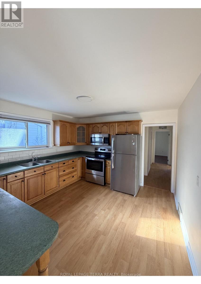 A kitchen with wooden cabinets and a refrigerator.