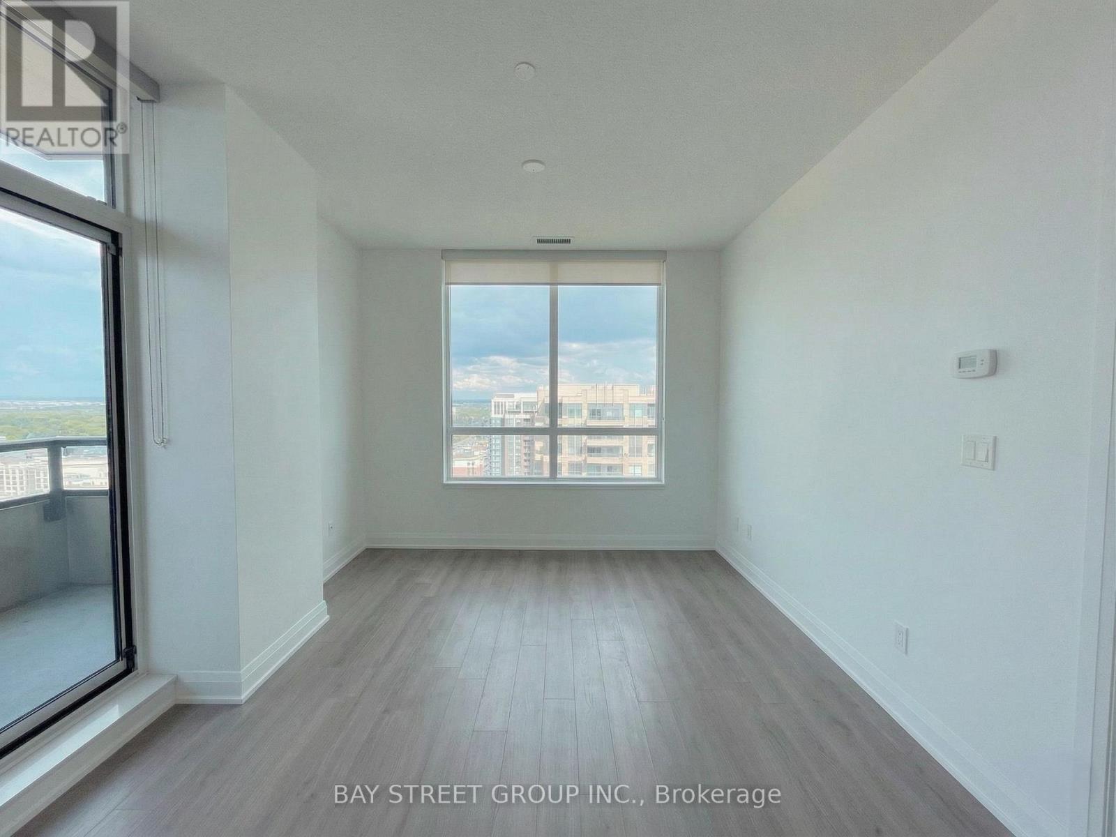A spacious room with a view of the city through a large window.