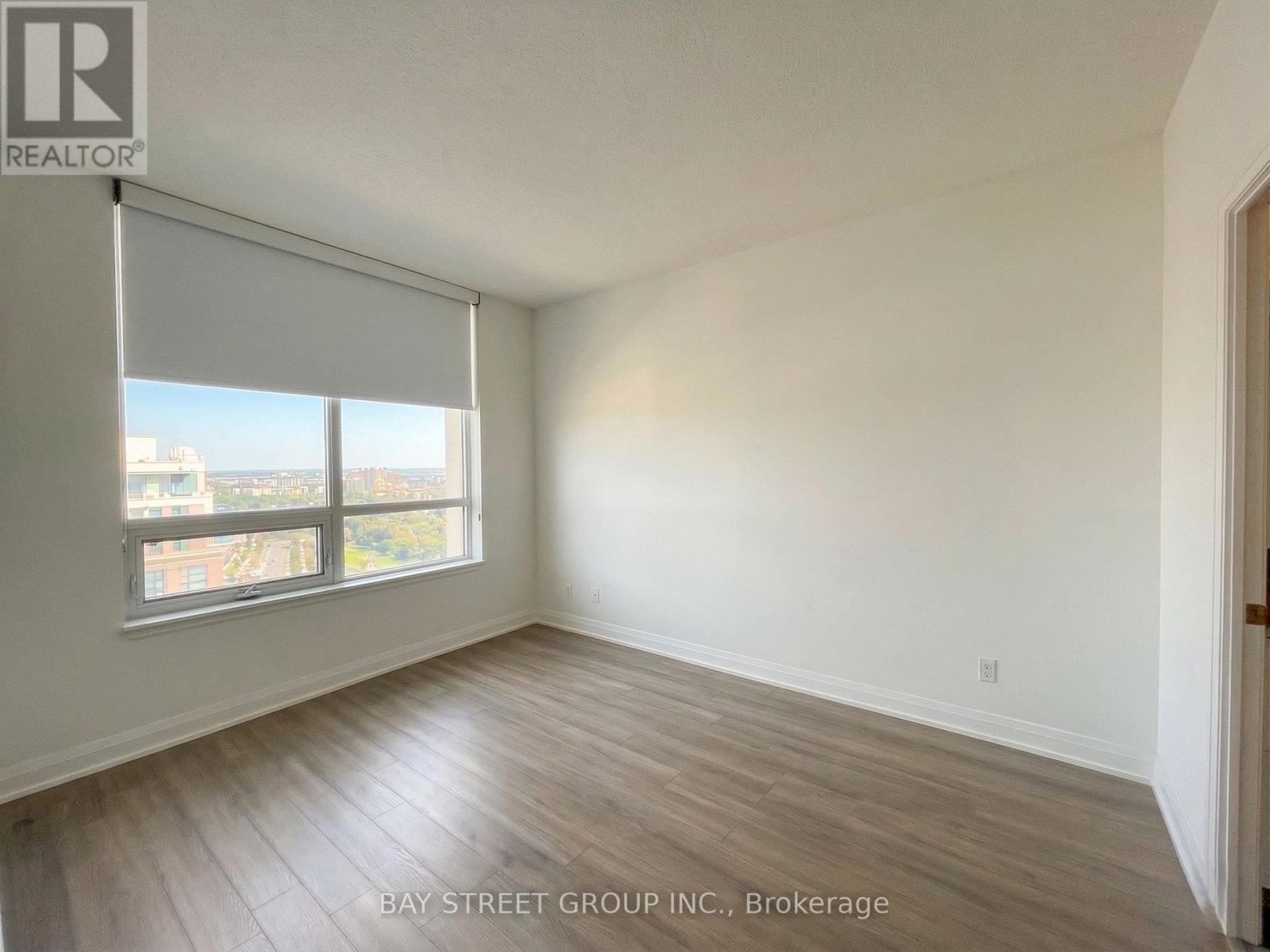 A room with a large window and wooden flooring.