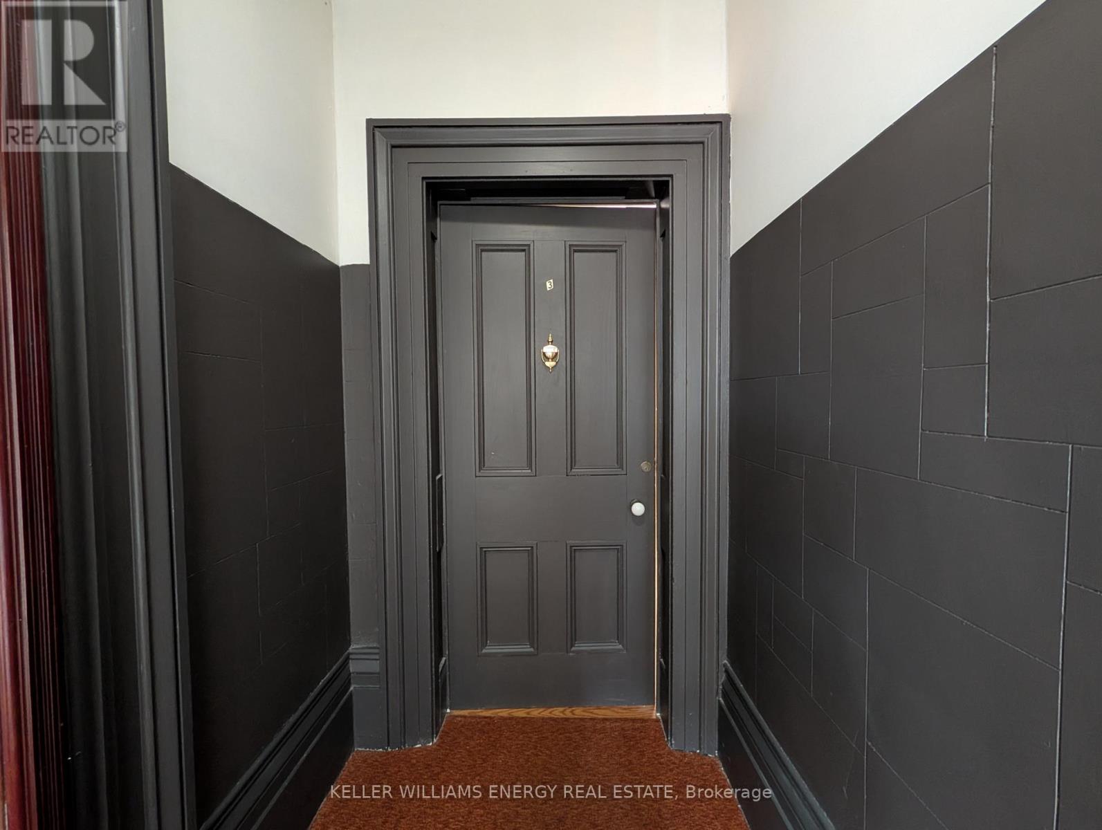 A dark doorway with a brown doormat in front.