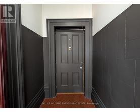 A dark doorway with a brown doormat in front.