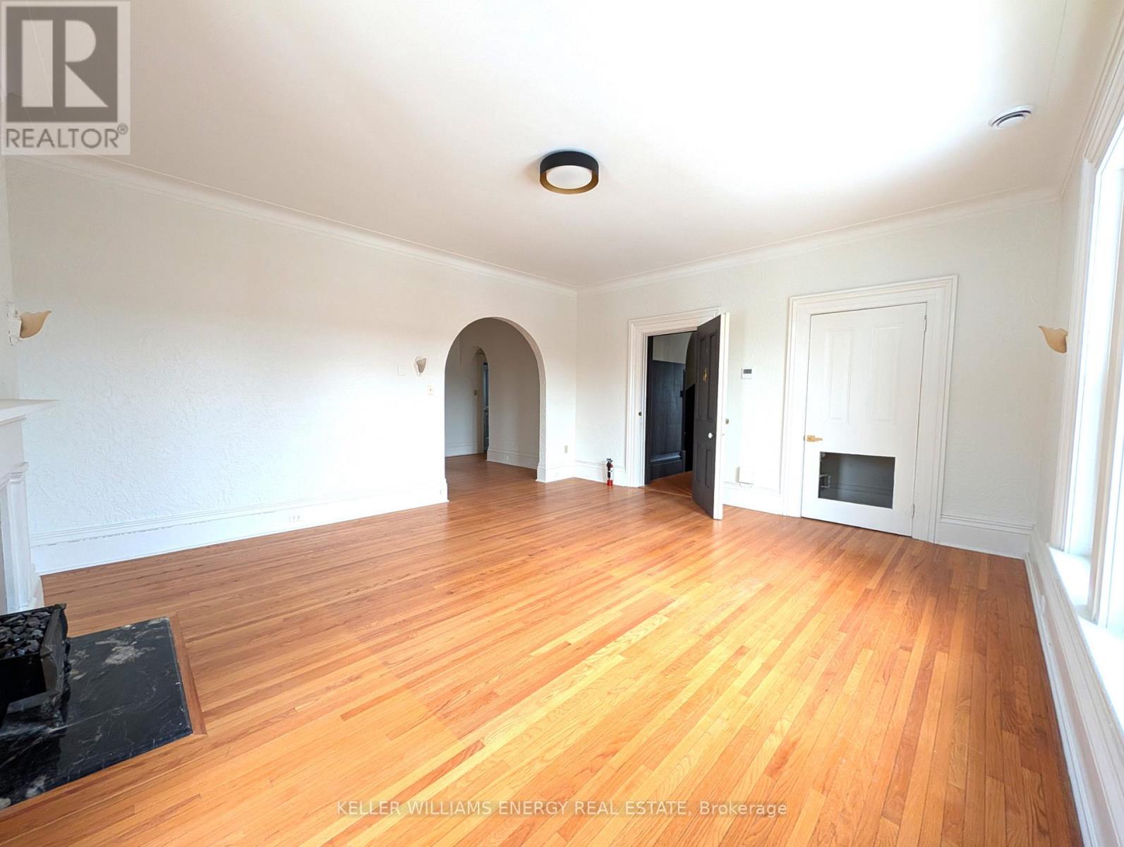 A spacious room with wooden floors and white walls.