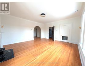 A spacious room with wooden floors and white walls.