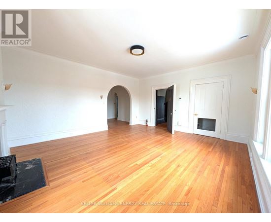 A spacious room with wooden floors and white walls.