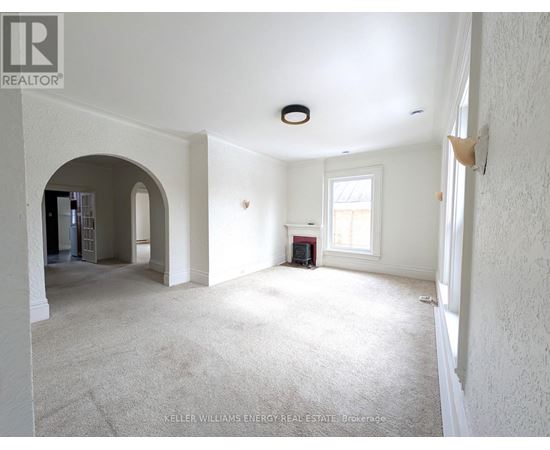 A spacious room with a carpeted floor and white walls.