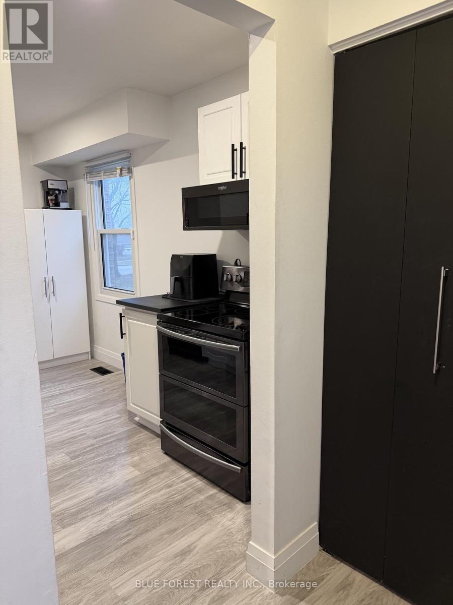 A kitchen with black cabinets and a white fridge.