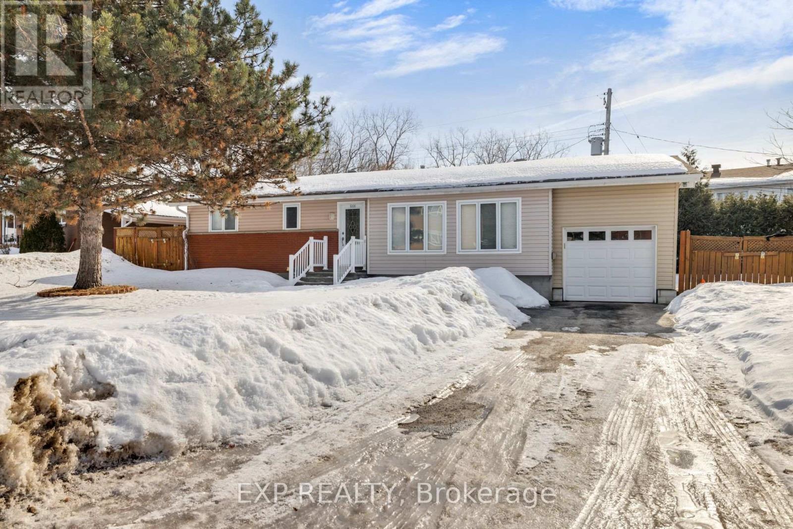 A house with a brown and beige exterior is surrounded by snow.