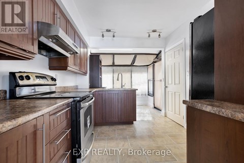 A kitchen with wooden cabinets and a black refrigerator.