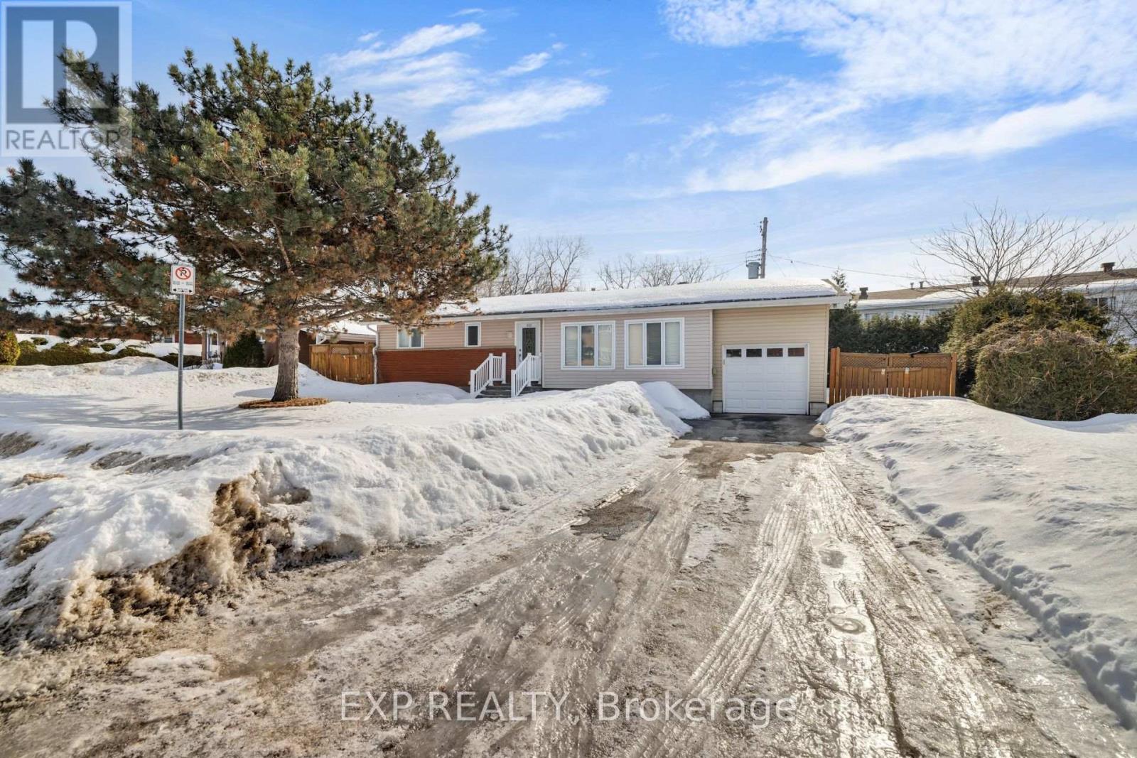 A house with a garage is for sale in a snowy area.