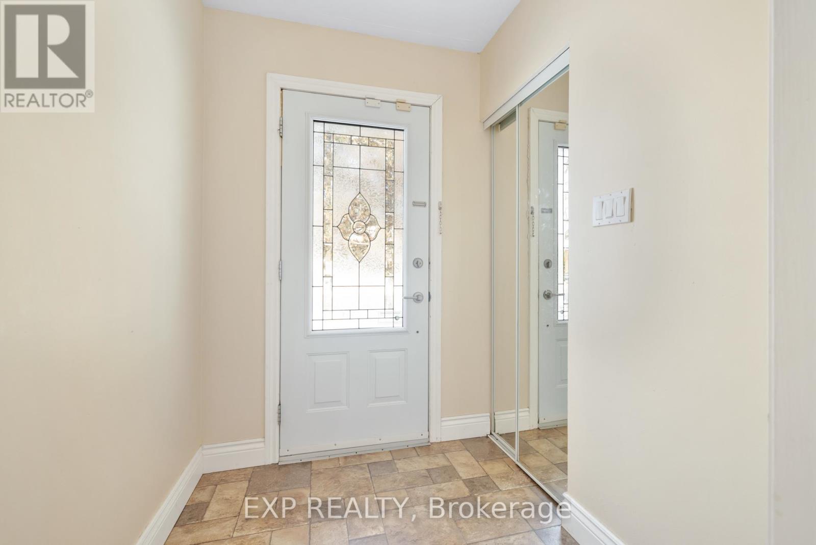 A white door with a glass window is in a room with beige walls.