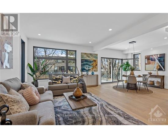 A living room with a couch, a coffee table, and a painting on the wall.