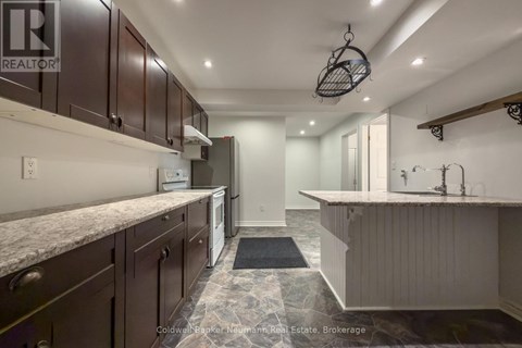 A kitchen with brown cabinets and a marble countertop.