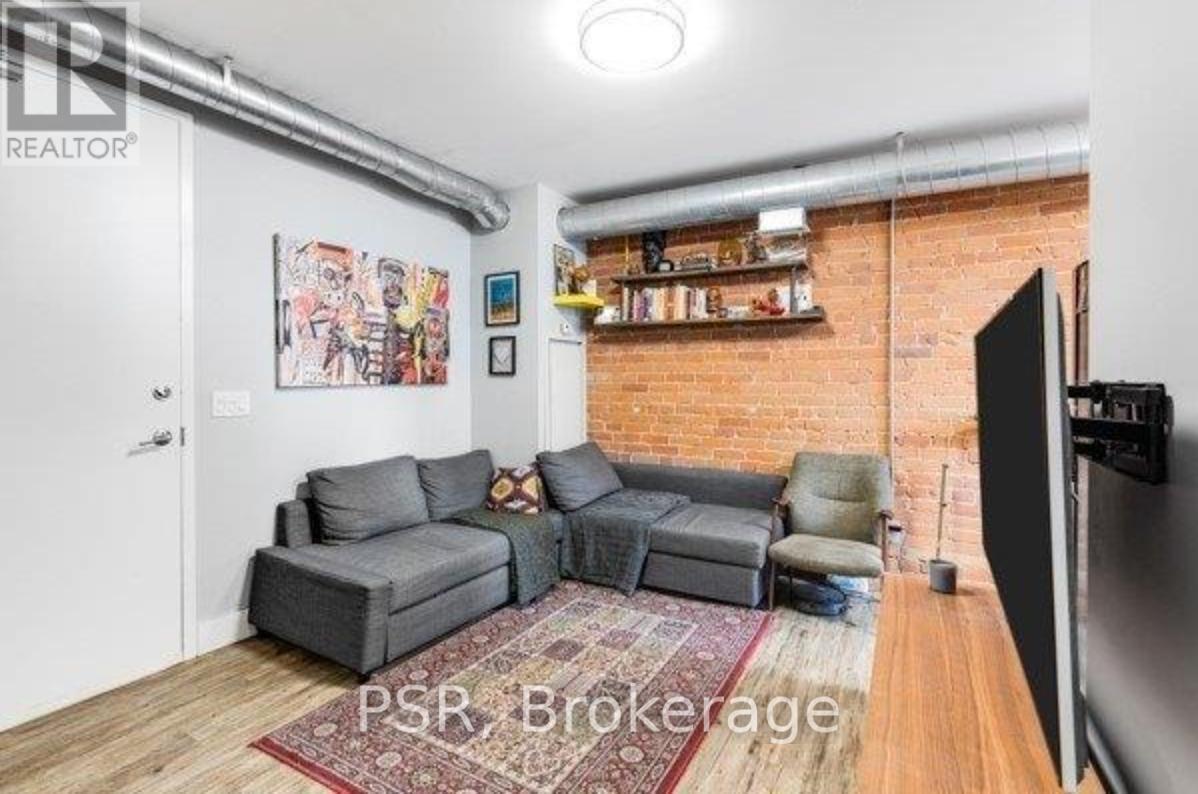 A living room with a grey sectional sofa and a red rug.