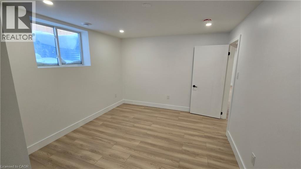 A room with a white door and a window with a view of a building outside.