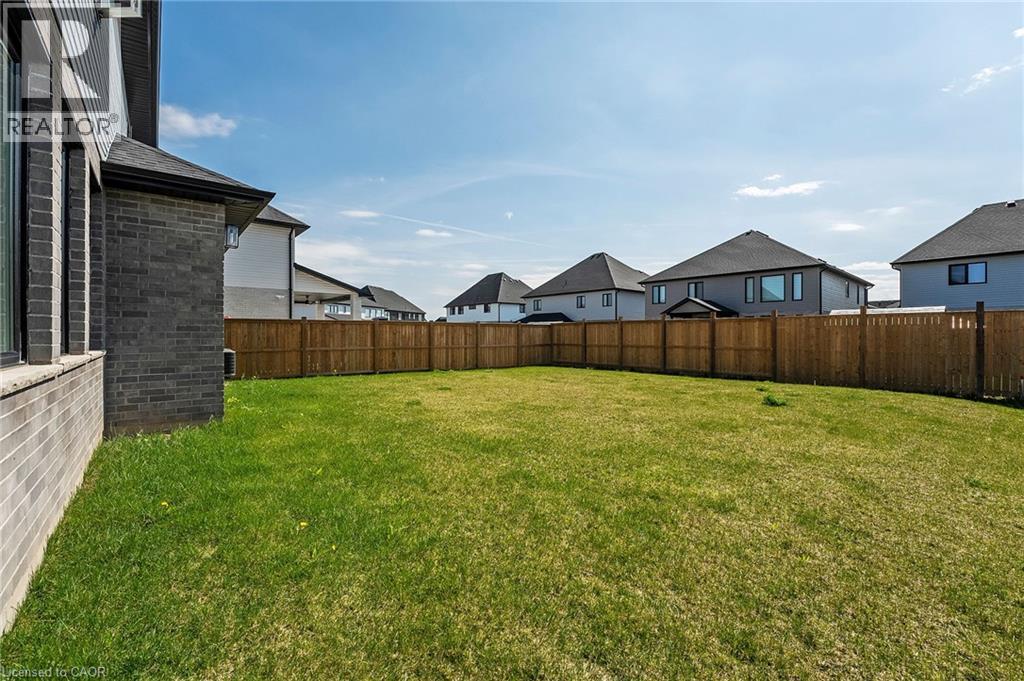A backyard with a wooden fence and houses in the background.