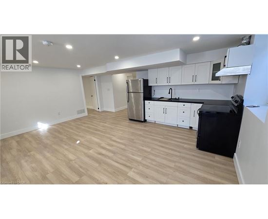 A kitchen with white cabinets and black countertops.