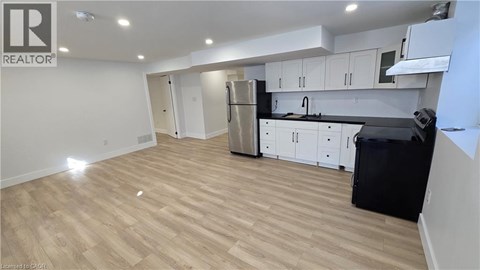 A kitchen with white cabinets and black countertops.