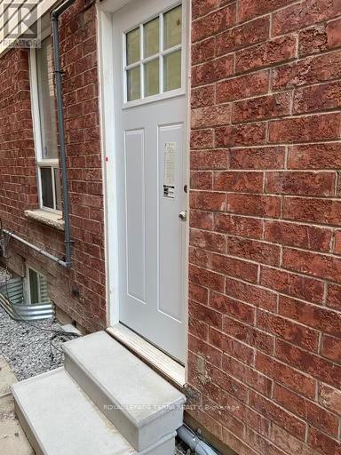 A white door is on a red brick wall.