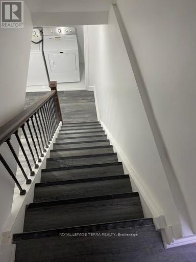 A staircase with a black handrail and wooden steps.