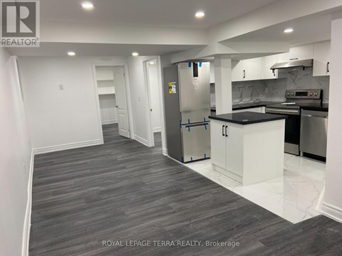 A kitchen with a refrigerator, cabinets, and a countertop is shown in this image.