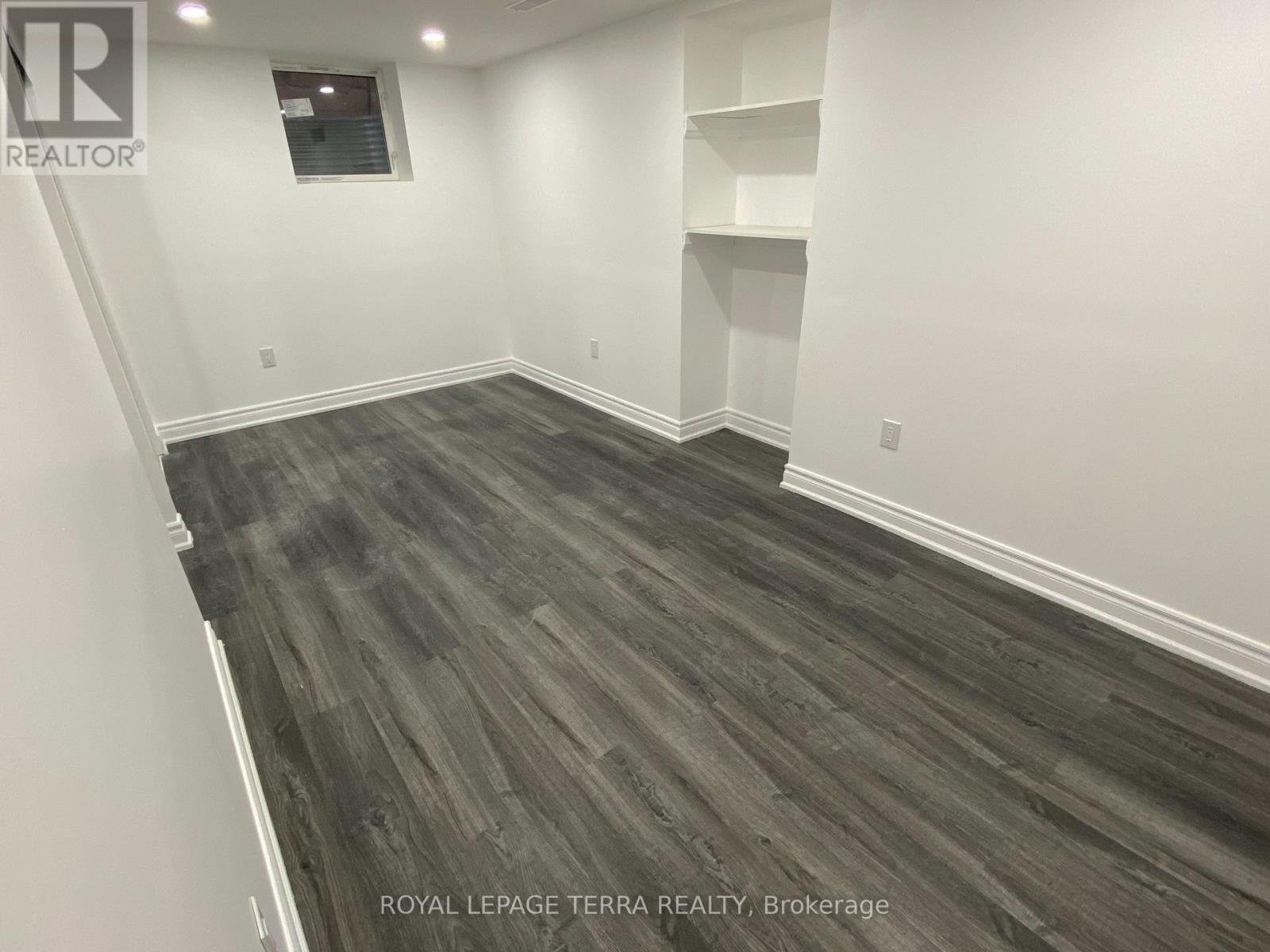 A room with wooden flooring and white walls.