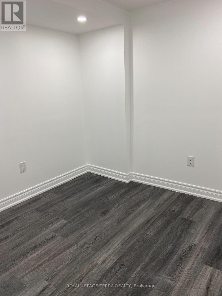 A room with wooden flooring and white walls.