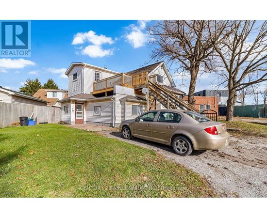 A car is parked in front of a house with a brown roof.