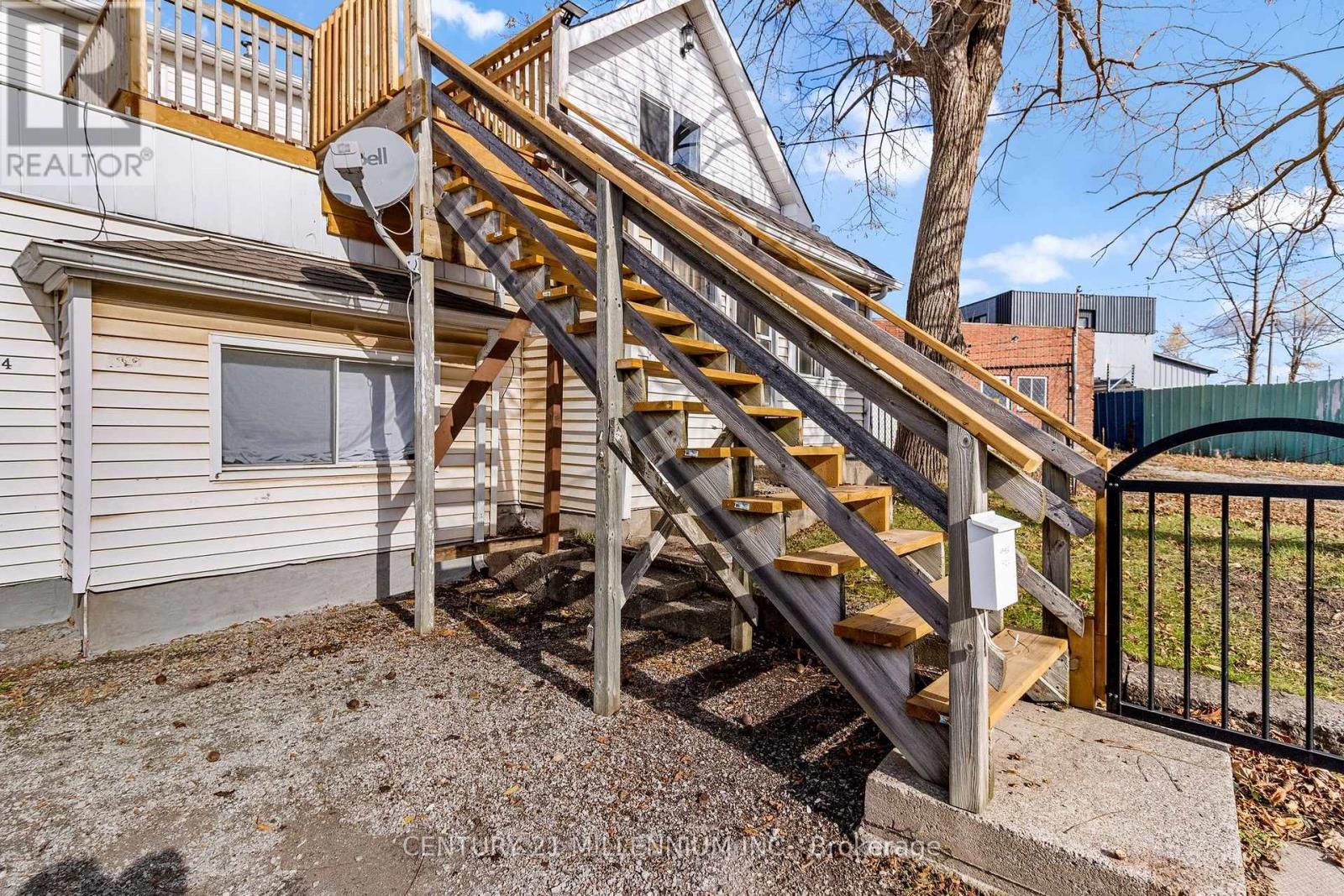 A wooden staircase with a metal railing leads up to a balcony.