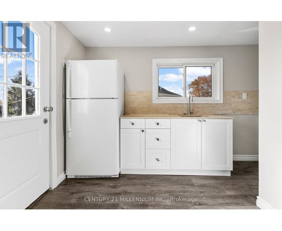 A kitchen with white appliances and cabinets is shown.