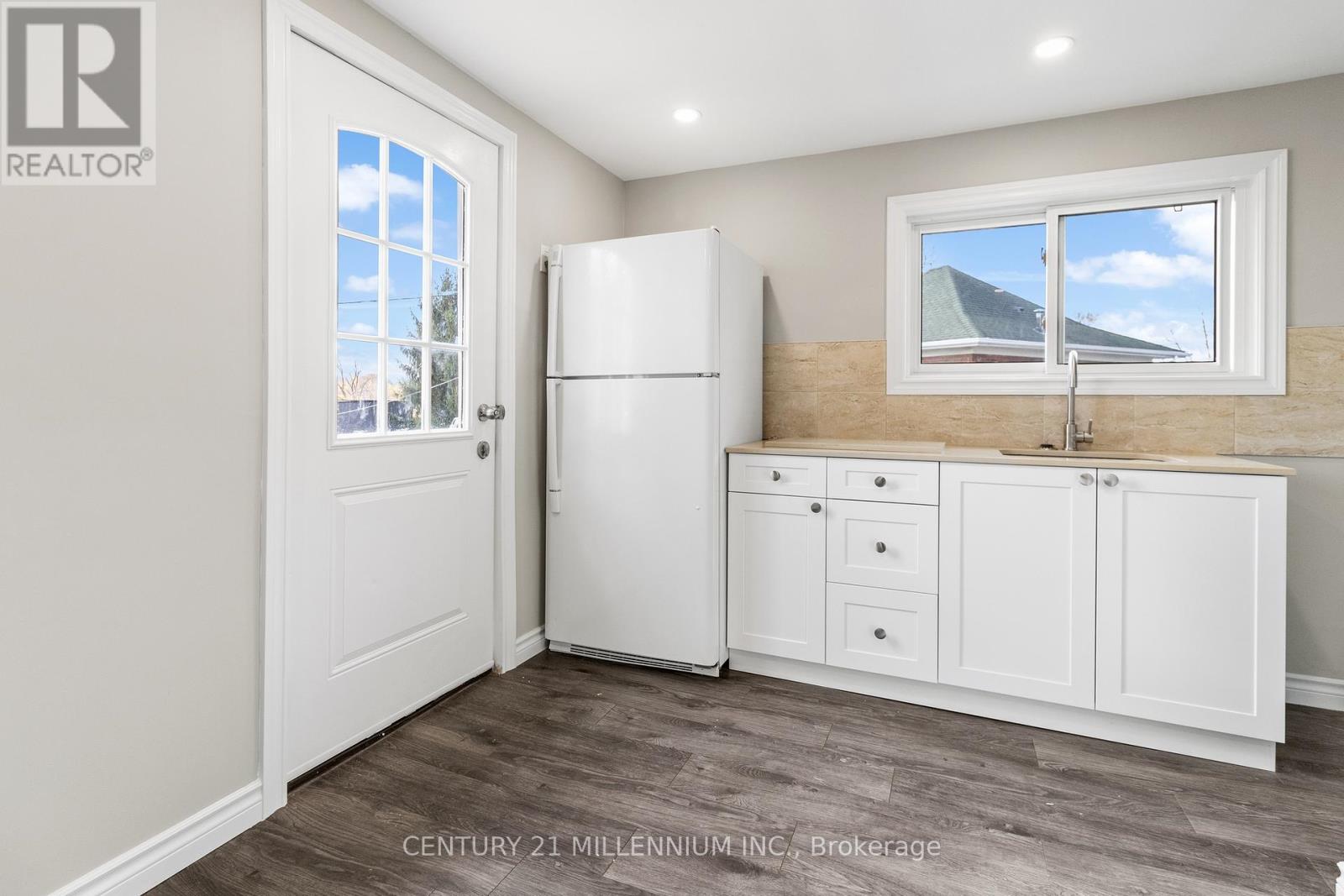 A kitchen with a white fridge and cabinets.