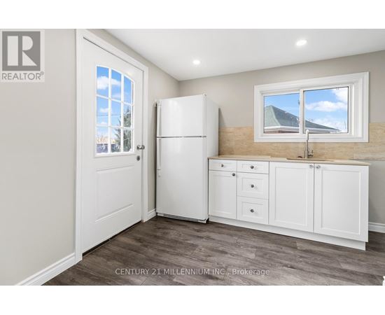 A kitchen with a white fridge and cabinets.