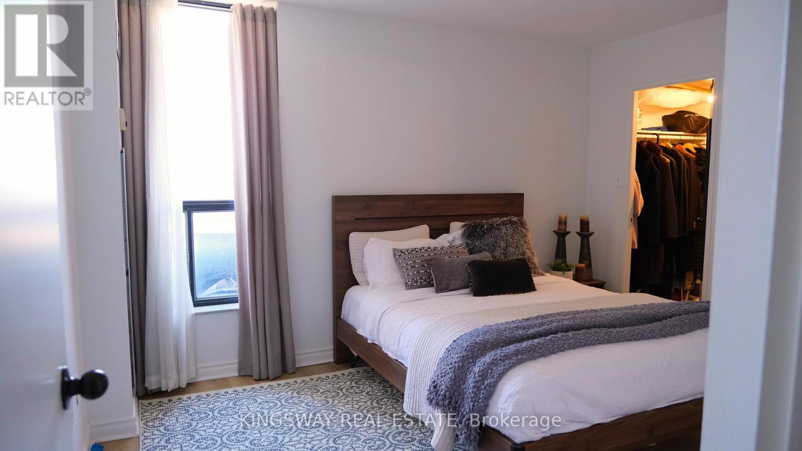 A bedroom with a large bed and a view of the city.