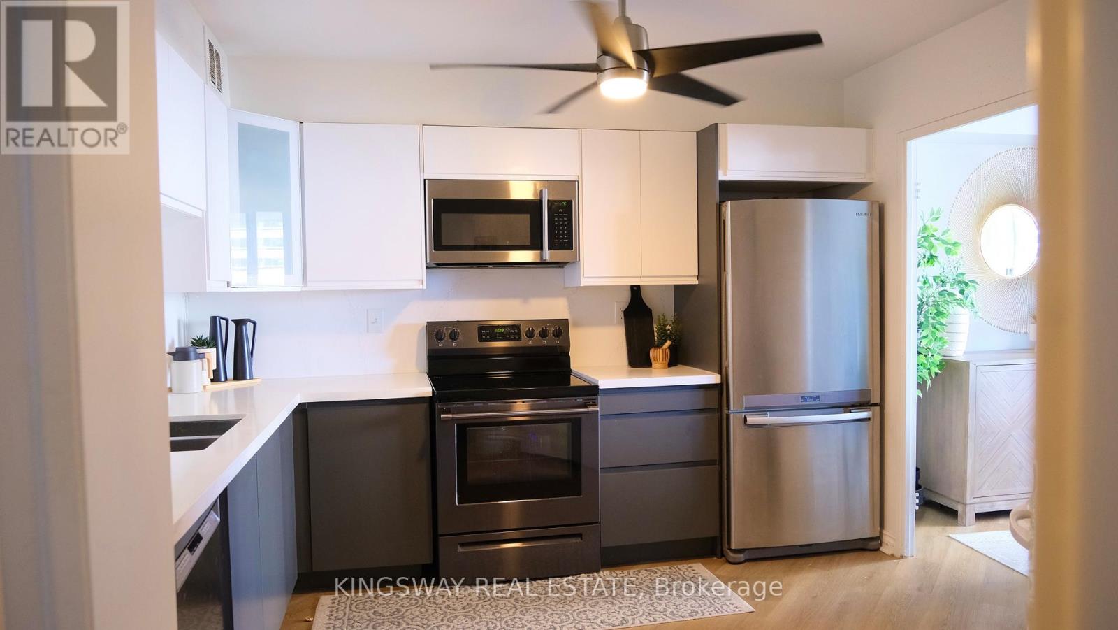 A kitchen with a stove top oven, microwave, and refrigerator.
