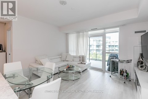 A modern living room with a glass table and white furniture.