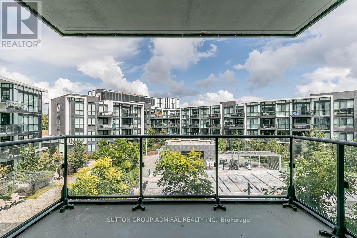 A view from a balcony overlooking a courtyard and apartment buildings.