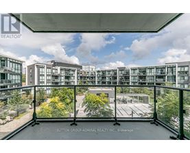 A view from a balcony overlooking a courtyard and apartment buildings.