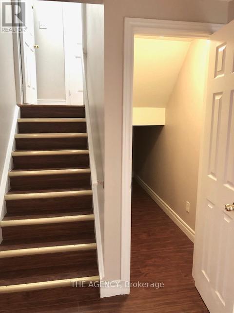 A hallway with a white door and a staircase.