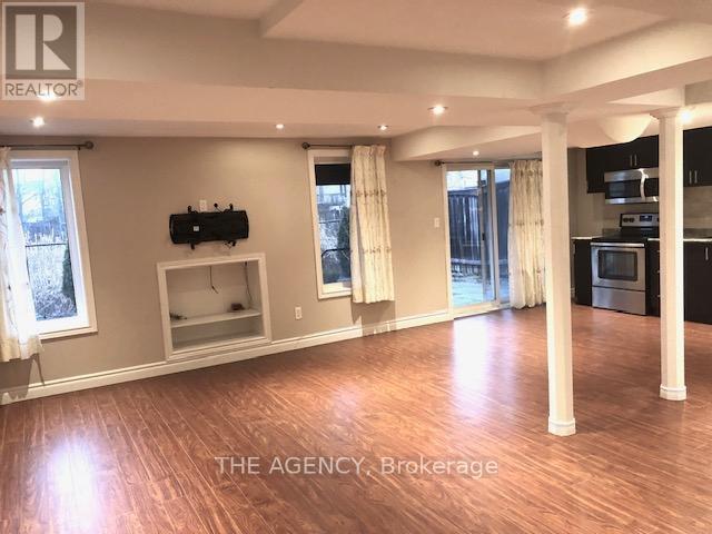 A spacious living room with a television and a kitchen area in the background.